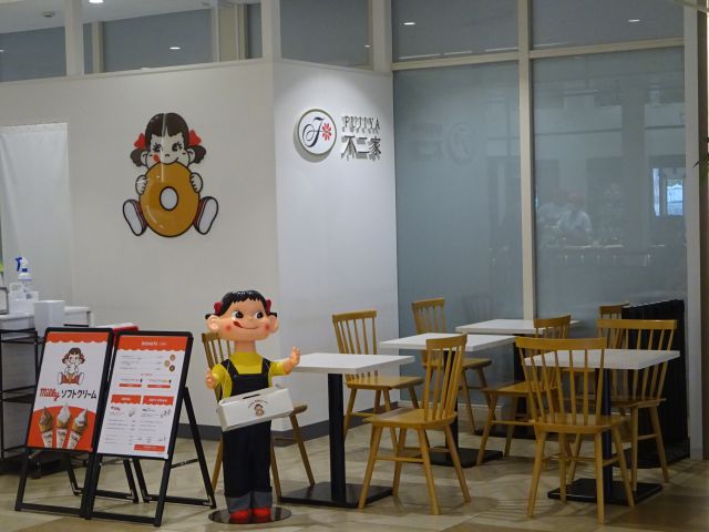 みなとみらい不二家「ペコちゃんmilkyドーナツ横浜ワールドポーターズ店」のイートインスペースとお店前のペコちゃん人形