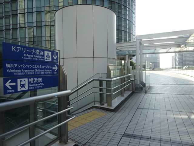 横浜駅からKアリーナ横浜のアクセス（ペデストリアンデッキ（みなとみらい歩道橋）の様子・Kアリーナ横浜、横浜アンパンマンこどもミュージアムの矢印案内あり）