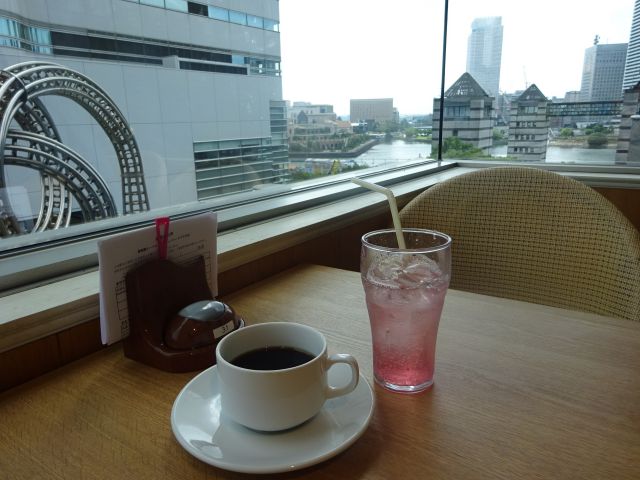 「果実園リーベル横浜ランドマークプラザ店」店内テーブル席から見える景色とドリンクバーで入れたコーヒー、ソフトドリンク