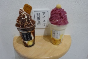 「アイスは別腹横浜関内店」で購入したモーツァルトと紅芋モンブランのパフェを店内撮影スポットの棚に置いたところ（アイスは別腹と書いてある）
