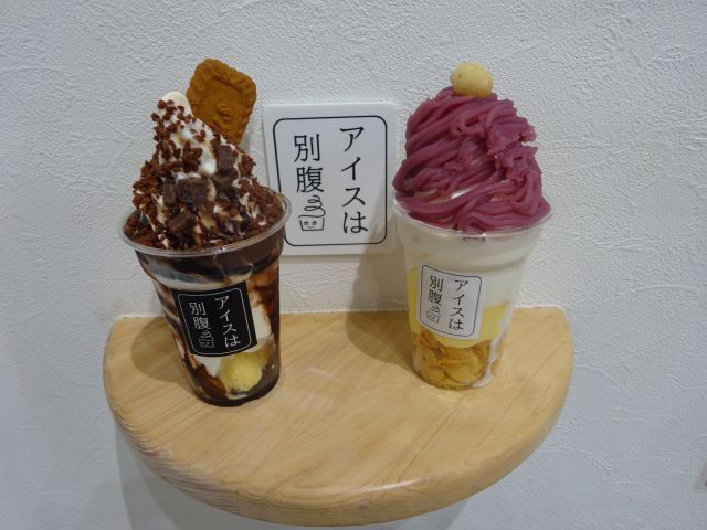 「アイスは別腹横浜関内店」で購入したモーツァルトと紅芋モンブランのパフェを店内撮影スポットの棚に置いたところ(アイスは別腹と書いてある)