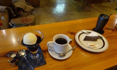 横浜・伊勢佐木モールの珈琲焙煎専門店「まめや」（yokohama mameya）で注文したホットコーヒーとコーヒーゼリー、アイスコーヒーとケーキがテーブルに並んでいるところ