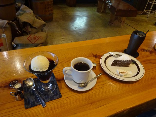 横浜・伊勢佐木モールの珈琲焙煎専門店「まめや」(yokohama mameya)で注文したホットコーヒーとコーヒーゼリー、アイスコーヒーとケーキがテーブルに並んでいるところ