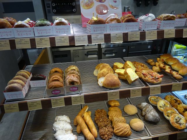 「パティスリーストラスブール日本大通り店」の生ドーナツとパンが並ぶ棚