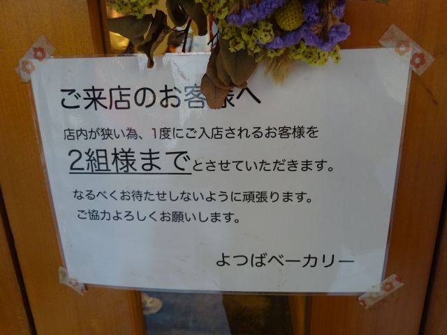横浜石川町・元町「よつばベーカリー」入口の案内（店内が狭い為、1度にご入店されるお客様を2組様までとさせていただきますと記載あり）