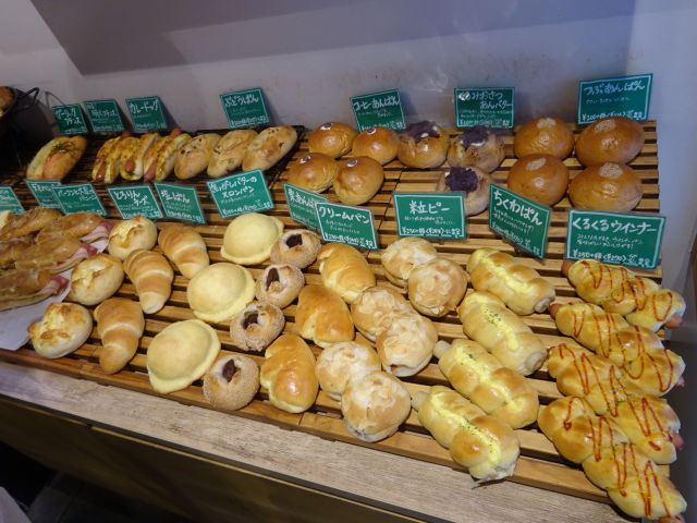 横浜石川町・元町「よつばベーカリー」店内の棚に並ぶ各種パン（あんぱん、メロンパン、各種総菜パン、塩パンなど色々）