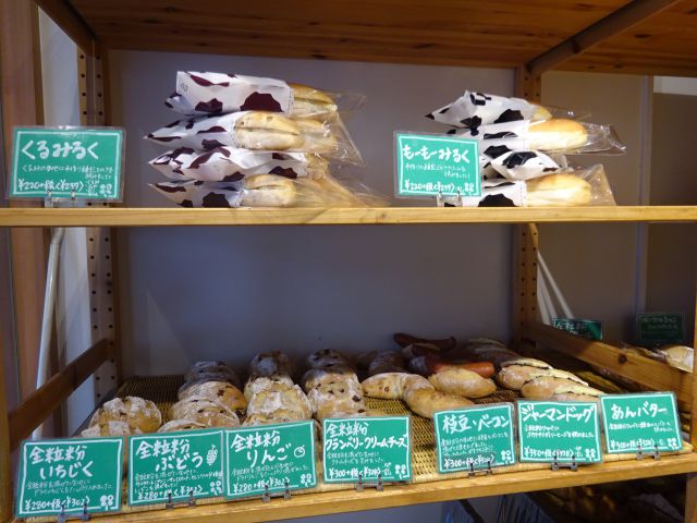 横浜石川町・元町「よつばベーカリー」店内の棚に並ぶ各種パン（各種全粒粉パン、みるくパン、あんバターなど）