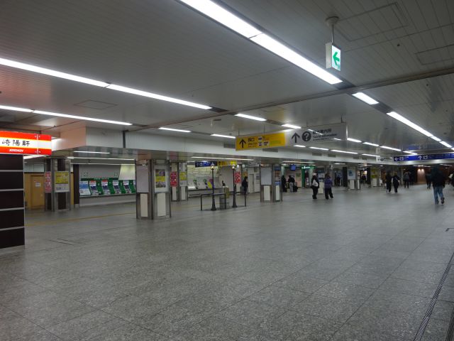 横浜駅中央通路全体の様子（中央に「赤い靴はいてた女の子像」と「ガス灯」のオブジェや崎陽軒売店の看板あり）