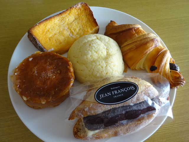 横浜駅東口「ジャン・フランソワ横浜ポルタ店」で購入したパンを皿に並べたところ（横濱メロンパン、クロワッサン・リュバン・オ・ショコラ、あんバターフランス、クイニーアマン、フレンチトースト）