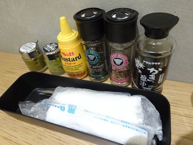 横浜みなとみらい・ランドマークプラザ「マロリーポークステーキみなとみらい店」のテーブル席に並ぶポークステーキ用の調味料