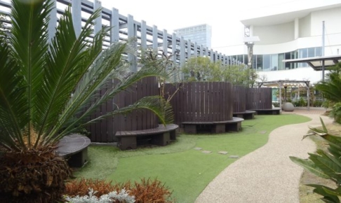 横浜ベイクォーター屋上「ベイガーデン」の芝生エリアとベンチが並んでいる様子