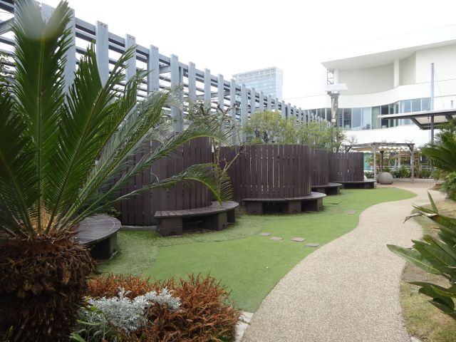 横浜ベイクォーター屋上「ベイガーデン」の芝生エリアとベンチが並んでいる様子