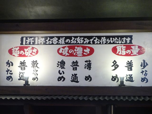 横浜駅西口・鶴屋町の横浜家系ラーメン「町田商店横浜駅前店」にてめんの硬さ、味の濃さ、脂の量の選択肢が書かれた看板