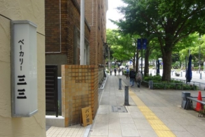 日本大通りのパン屋「ベーカリー三三」の入口にあるお店の看板と日本大通りの様子