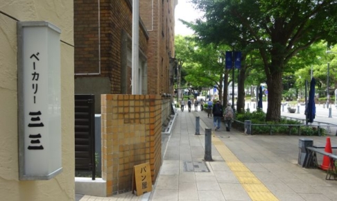 日本大通りのパン屋「ベーカリー三三」の入口にあるお店の看板と日本大通りの様子