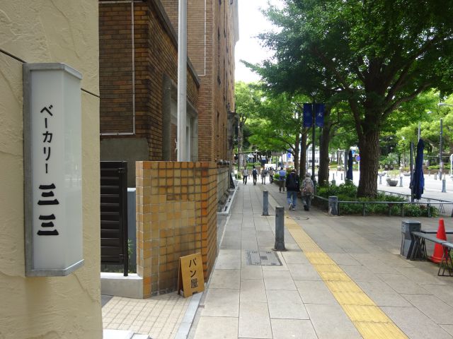 日本大通りのパン屋「ベーカリー三三」の入口にあるお店の看板と日本大通りの様子