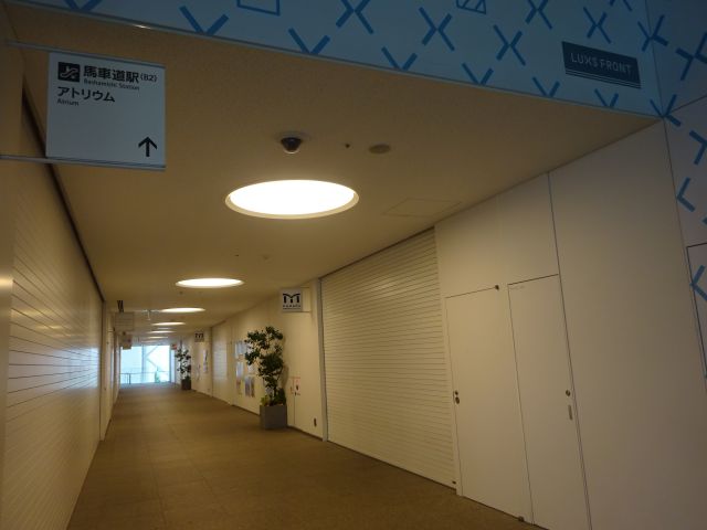 桜木町駅から馬車道駅の行き方（横浜市役所2階の通路、頭上にアトリウム・馬車道駅の矢印案内看板あり）