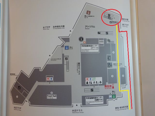 桜木町駅から馬車道駅の行き方（横浜市役所アトリウム1階のフロアマップ、桜木町駅方面に赤色線（外経由）、黄色線（市役所内経由）を引いている）