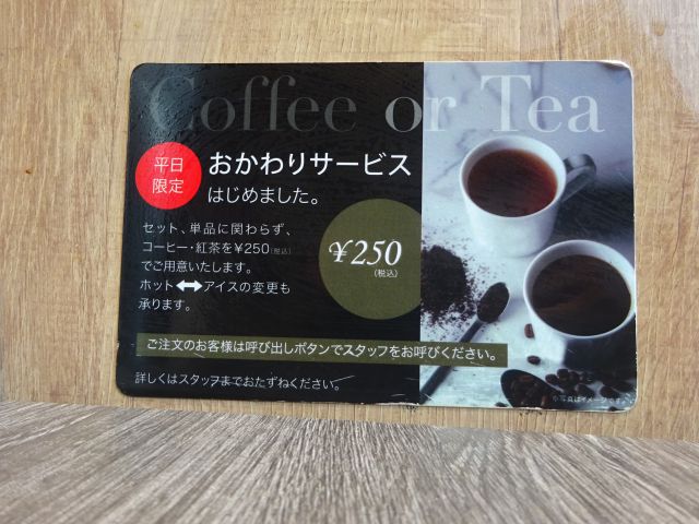 「モスプレミアム桜木町クロスゲート店」のテーブル席に貼られた平日限定おかわりサービス（コーヒー・紅茶）の案内