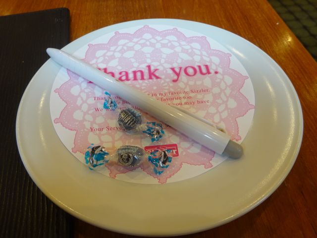 横浜みなとみらい「シズラーランドマークプラザ店」のサンキューカード（感想・要望を書く紙）の上置かれたミントキャンディ