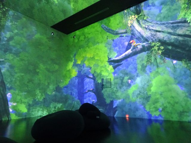 BASEGATE横浜関内「ワンダリア横浜」ゾーン3の様子（木の枝にいるヤマネコの映像とビーズクッションが床に置いてある）