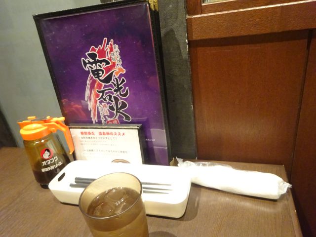 桜木町・コレットマーレ「電光石火横浜みなとみらい店」のテーブル席（メニュー表、オタフクソース、水が置かれている）